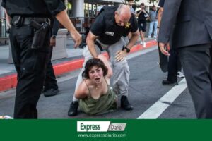 Manifestante golpeada por la policía y tirada al suelo cuando se acercan a la caravana de Joe Biden